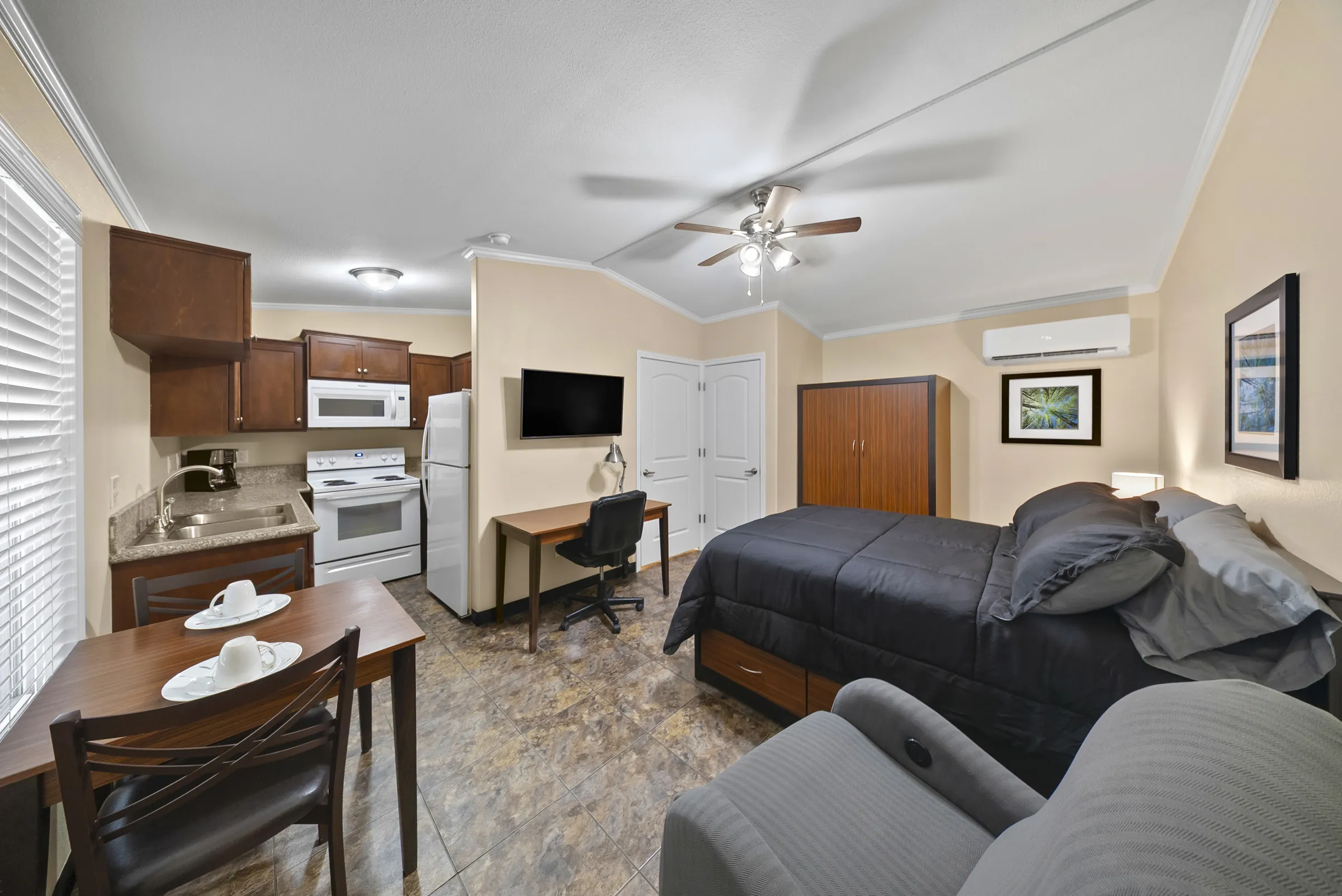 Bayou studio suite with queen bed, desk, dining table and full kitchen
